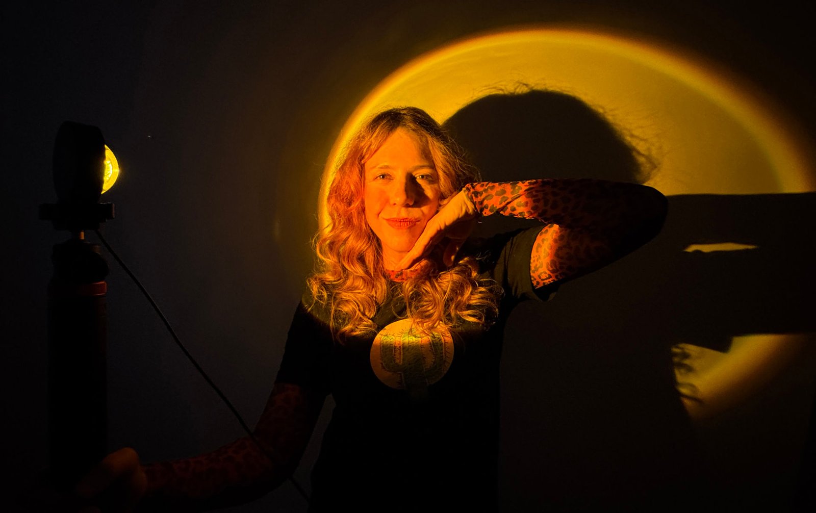 Lorena Riga en su estudio de Madrid sostiene una Lampara de Luz del Atardecer con su mano, mientras hace contenido de Marca personal para su canal de YouTube